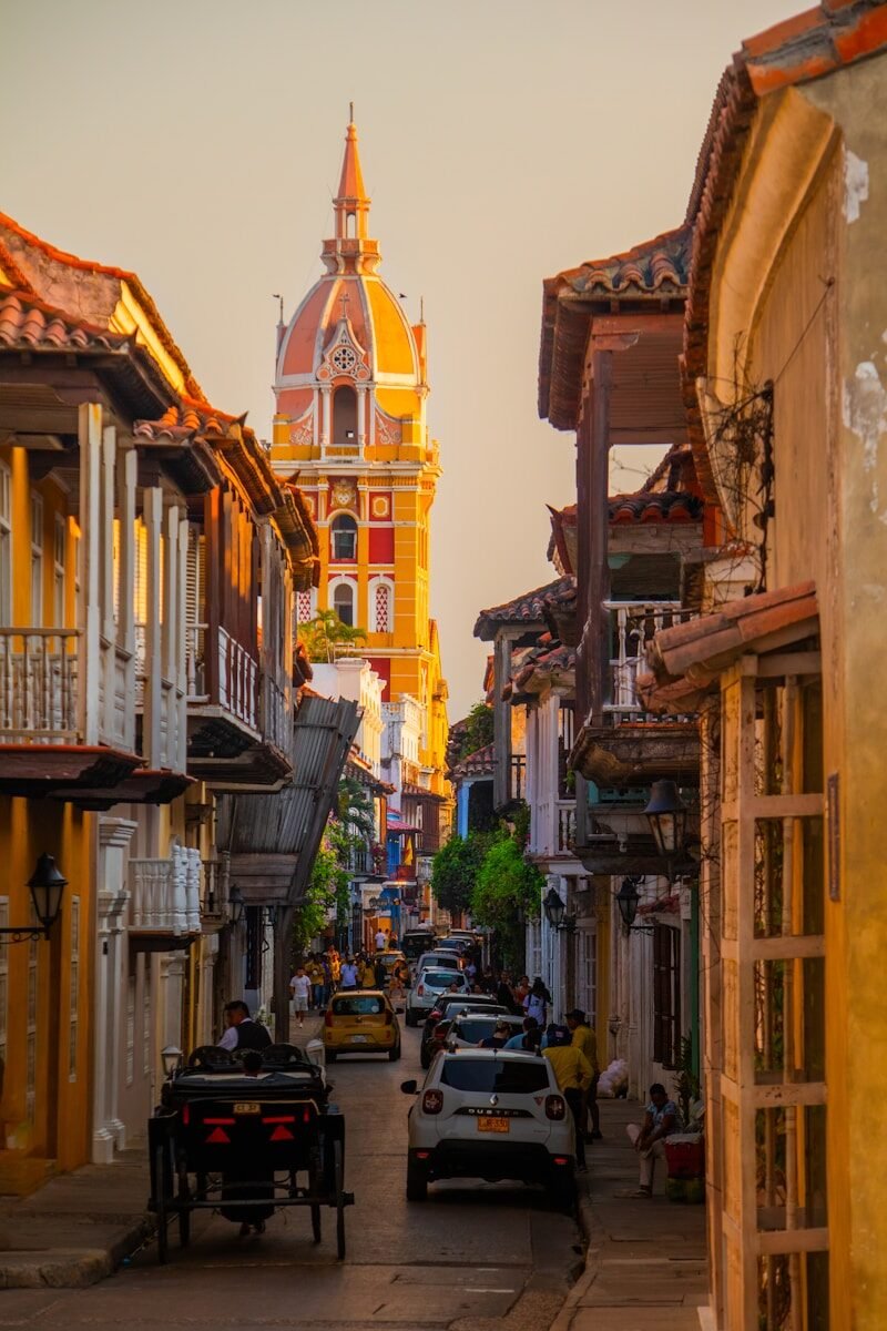 a city street with a church steeple in the background