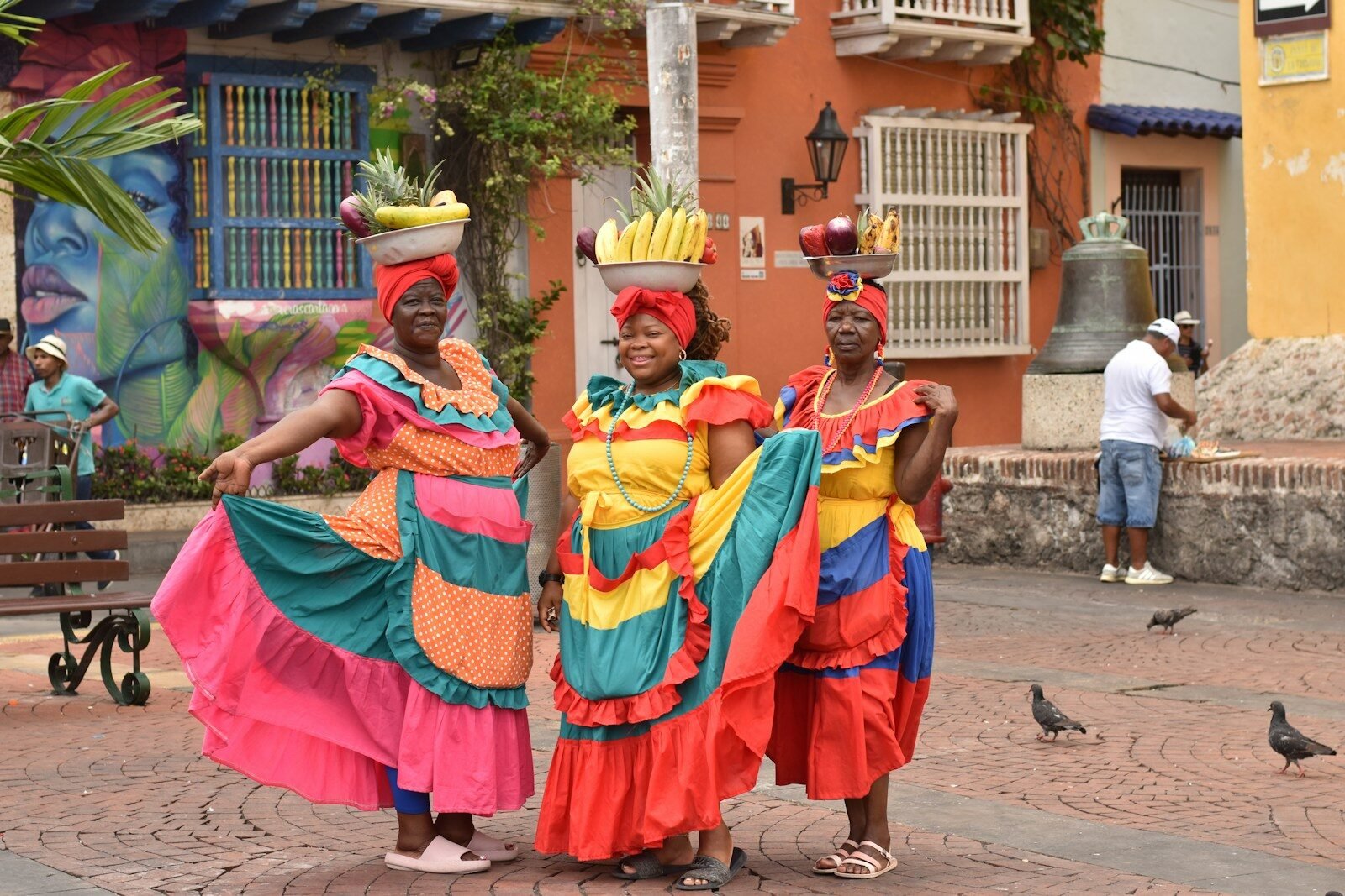 a group of women in colorful dresses standing next to each other