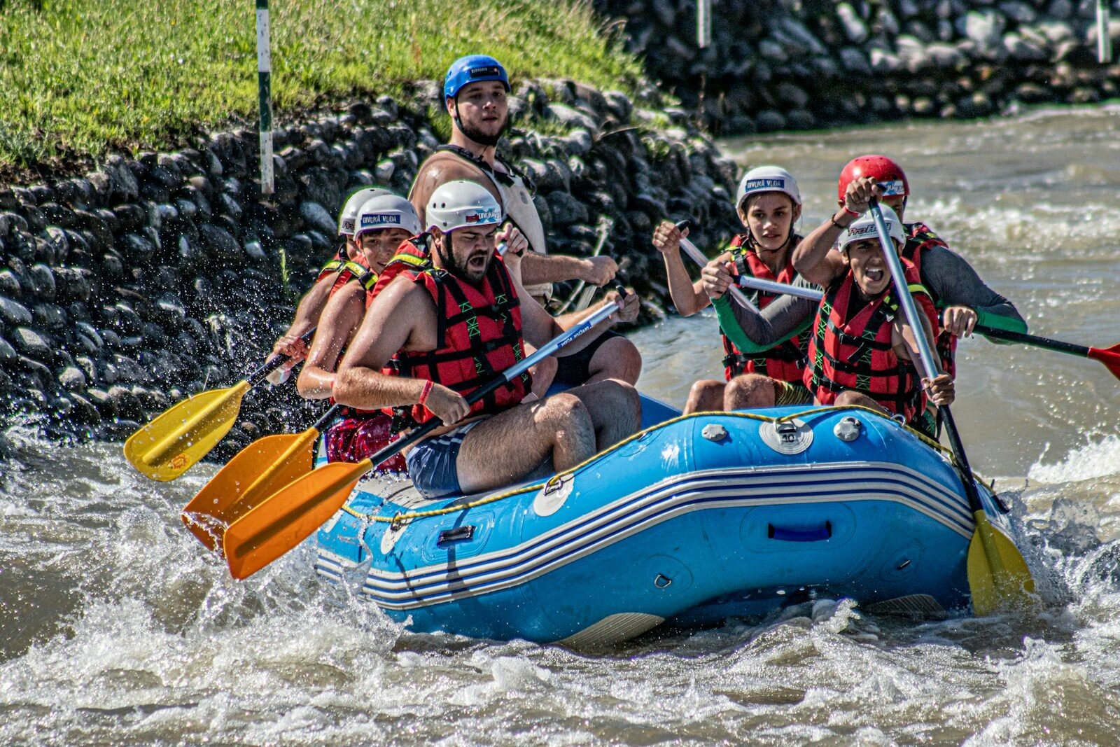 people riding on blue and yellow inflatable boat during daytime