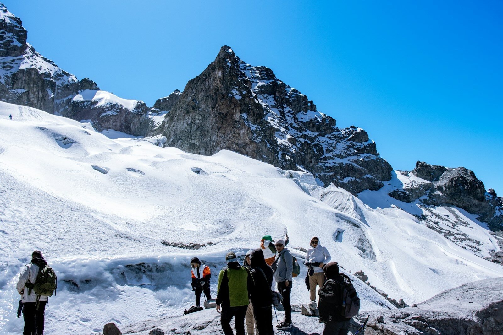 a group of people standing on top of a snow covered mountain